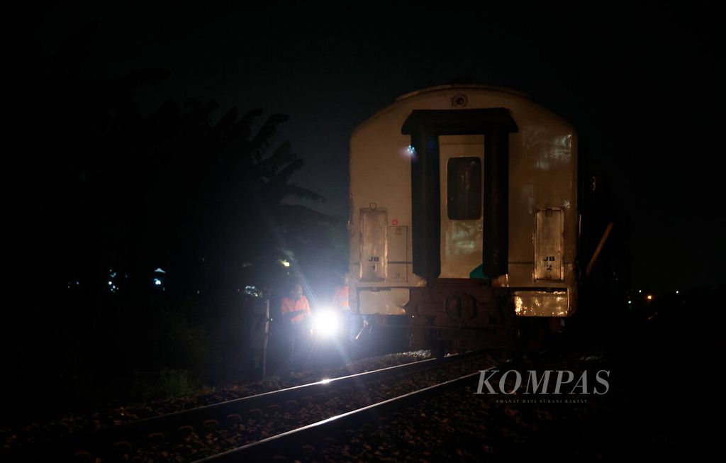Petugas dari PT Kereta Api Indonesia memeriksa salah satu gerbong yang terbakar sesaat setelah lokomotif menabrak truk di perlintasan sebidang Madukoro Raya, Kota Semarang, Jawa Tengah, Selasa (18/7/2023). 