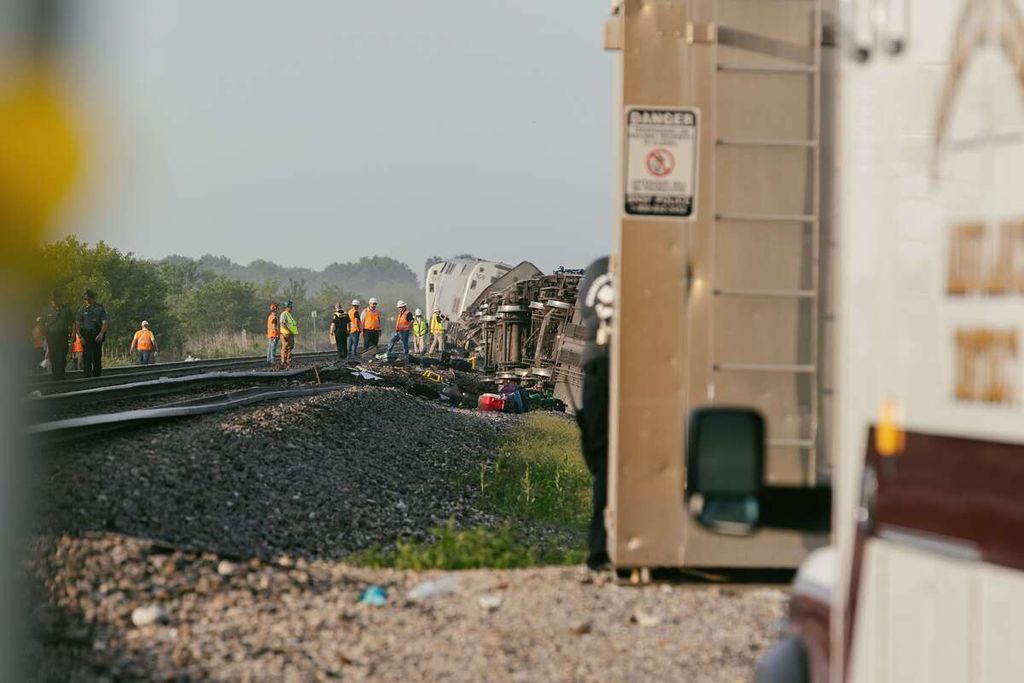 Polisi dan pekerja dari perusahaan kereta api tengah bekerja dan melakukan penyelidikan di lokasi kecelakaan kereta Southwest Chief, Senin (27/6/2022) di Mendon, Missouri, Amerika Serikat.