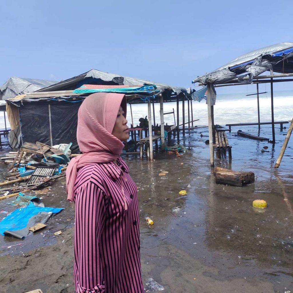 Warga melihat kondisi warung-warung seusai disapu gelombang tinggi di Pantai Setrojenar, Kebumen, Jawa Tengah, Selasa (30/8/2022).