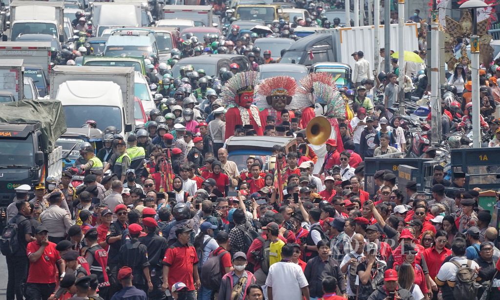 Suasana rombongan yang mengiringi pasangan bakal calon gubernur-wakil gubernur, Pramono Anung-Rano Karno, menuju Kantor KPU Provinsi DKI Jakarta, Jalan Salemba Raya, Jakarta, untuk mendaftar Pilkada Jakarta 2024, Rabu (28/8/2024). Selain massa pendukung, pasangan cagub-cawagub, Pramono Anung-Rano Karno, ini juga diiringi sejumlah kesenian Betawi, seperti ondel-ondel dan musik tanjidor. Pasangan Pramono Anung-Rano Karno yang diusung PDI-P ini menjadi bacalon pertama yang datang mendaftar ke KPU DKI 2024 untuk Pilkada DKI Jakarta 2024. 