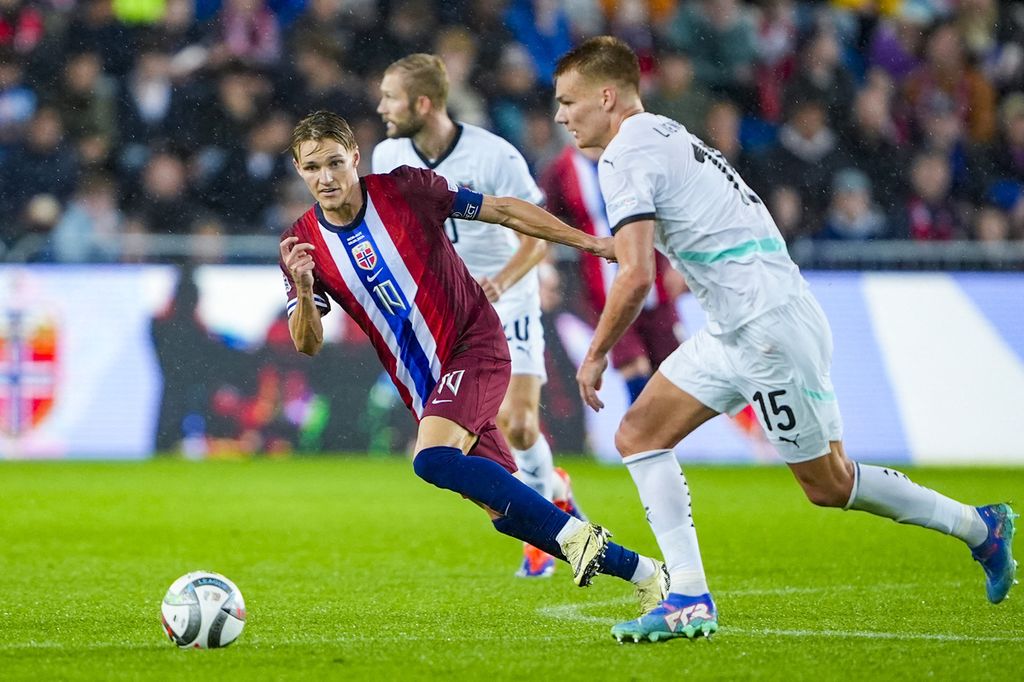 Gelandang Norwegia, Martin Odegaard (kiri), mengejar bek Austria, Philipp Lienhart, pada laga Liga Nasional Eropa di Stadion Ullevaal di Oslo, Norwegia, Selasa (10/9/2024) dini hari WIB. Odegaard mengalami cedera pada laga itu. Dia kemungkinan harus absen pada laga derbi lawan Tottenham Hotspur, Minggu (15/9/2024).