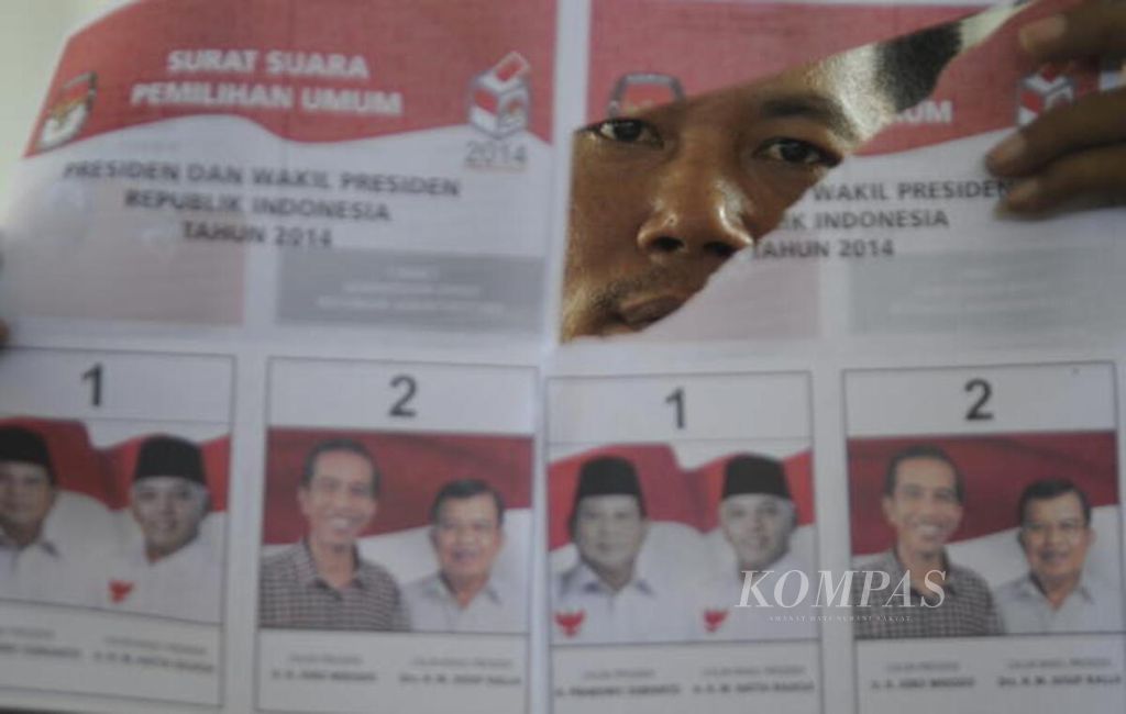Petugas menunjukkan surat suara Pilpres 2014 yang ditemukan rusak saat penyortiran surat suara di Kantor KPUD Kota Surabaya, Jawa Timur, Rabu (25/6/2014)