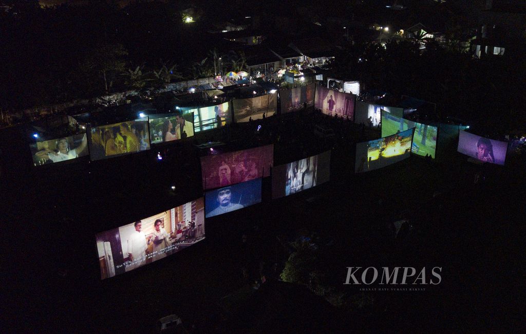 Foto aerial festival layar tancap di sebuah lapangan di Babakan, Kecamatan Setu, Tangerang Selatan, Banten, Rabu (18/1/2023) malam. Pemutaran film layar tancap secara bersamaan tersebut menjadi hiburan masyarakat sekitar. Kegiatan itu dalam rangka silaturahmi para pencinta film layar tancap dan memperingati hari ulang tahun pertama komunitas pencinta film LCD Tangsel.