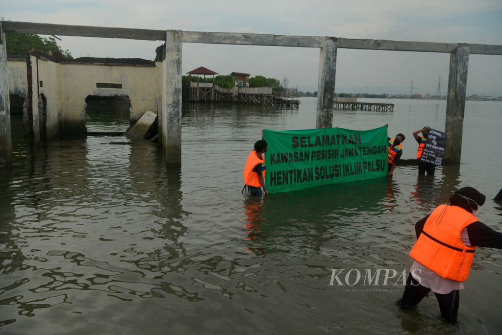 Aktivis dari dari berbagai komunitas membentangkan spanduk yang berisi tentang ajakan penyelamatan pesisir Jawa Tengah di Tambakrejo, Kota Semarang, Jawa Tengah, Jumat (5/11/2021). 