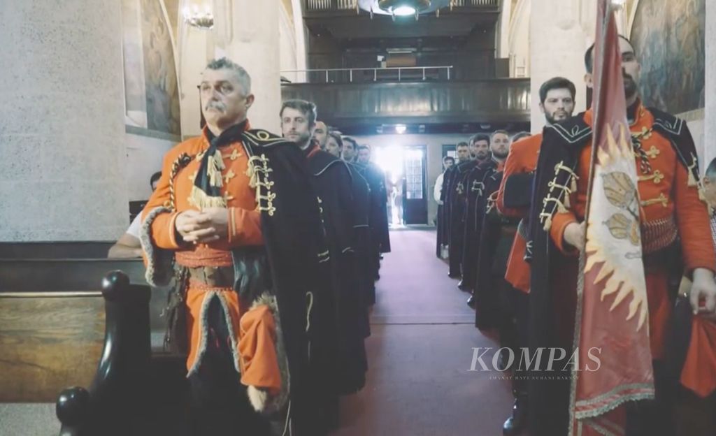 Dalam tangkapan layar dari video yang disiarkan pada Mei 2017 ini, warga Zagreb, Serbia mengikuti pawai dengan mengenakan busana anggota resimen Cravat. Pada abad 17, resimen itu dikenal pula sebagai Resimen Kroasia karena seluruh anggotanya dari Kroasia. Resimen itu salah satu kelompok tentara bayaran dalam berbagai perang di Eropa.