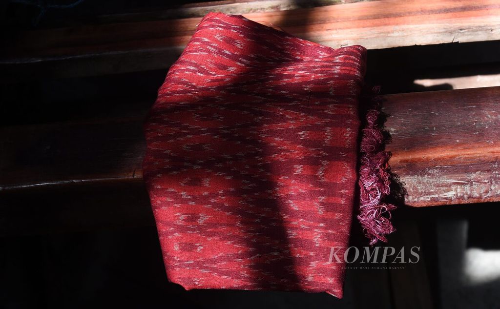 Kain sarung yang baru selesai dibuat dengan alat tenun bukan mesin di Desa Iker-iker Geger, Kecamatan Cerme, Kabupaten Gresik, Jawa Timur, Rabu (22/6/2022). Untuk satu kain yang dihasilkan, perajin mendapat upah Rp 55.000. Jika dikerjakan secara serius, dalam satu hari satu perajin dapat menghasilkan satu lembar kain sarung. Sebagian besar pekerja adalah ibu rumah tangga sehingga waktunya dibagi antara mengurus keluarga dan membuat tenun. 