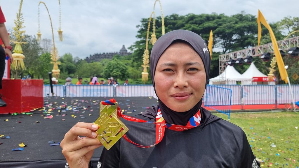 Ai Kusmiati menunjukkan medali juara nya di Borobudur Marathon, Minggu (13/11/2022).