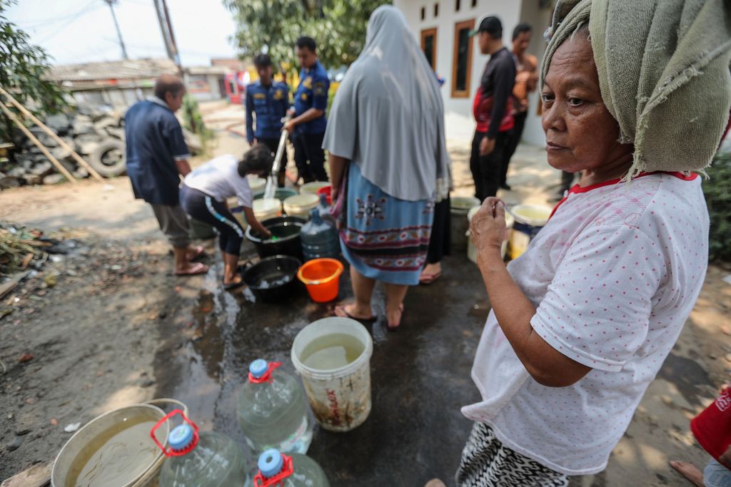 Warga menunggu wadah miliknya terisi air bersih di Kelurahan Keranggan, Kecamatan Setu, Kota Tangerang Selatan, Banten, Senin (18/9/2023). 