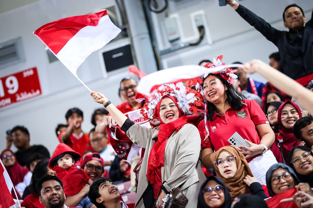 Aksi suporter Indonesia saat memberi dukungan melawan Korea Selatan pada pertandingan perempat final Piala Asia U-23 2024 di Stadion Abdullah bin Khalifa, Doha, Qatar, Jumat (26/4/2024) dini hari WIB.   