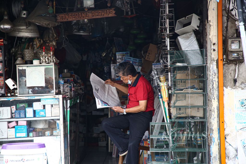 Seorang warga lanjut usia membaca surat kabar saat menunggu tokonya di Pasar Lama, Kota Tangerang, Banten, Sabtu (29/5/2021). Lansia merupakan mereka yang masuk ke dalam kelompok usia 60 tahun ke atas. Masih banyak dijumpai lansia yang tetap produktif beraktivitas dalam keseharian mereka. 