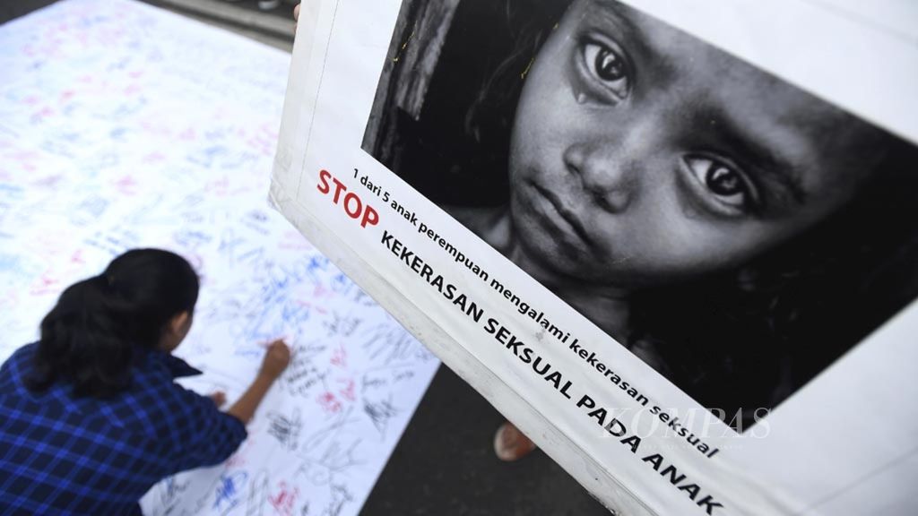 Warga membubuhkan tanda tangan saat aksi damai tolak kekerasan seksual terhadap perempuan di Jalan Darmo, Surabaya, Minggu (9/12/2018). Mereka mendesak RUU Penghapusan Kekerasan Seksual segera disahkan.