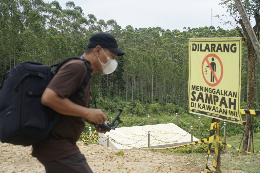 Pengunjung Titik Nol IKN melintasi plang peringatan dilarang membuang sampah di sekitar bakal lokasi ibu kota baru di Kecamatan Sepaku, Penajam Paser Utara, Kalimantan Timur, Jumat (27/5/2022).