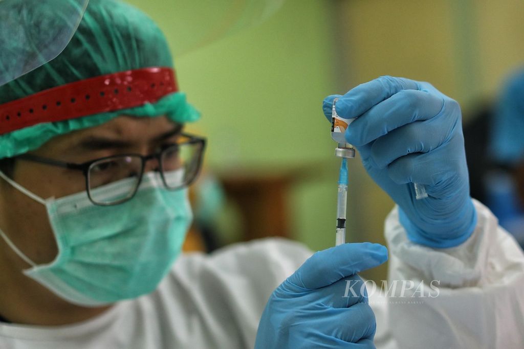 Vaksinator menyiapkan vaksin Covid-19 tahap pertama saat vaksinasi massal terhadap pedagang di Pasar Induk Kramatjati, Jakarta, Selasa (9/3/2021).