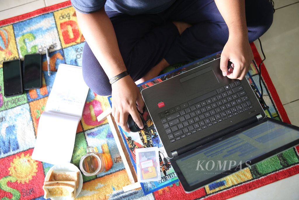 Seorang pegawai bank bekerja di rumahnya di Tangerang Selatan, Banten, Selasa (17/3/2020). Sejumlah kantor dan perusahaan menerapkan sistem bekerja dari rumah untuk meminimalkan penularan Covid-19. 