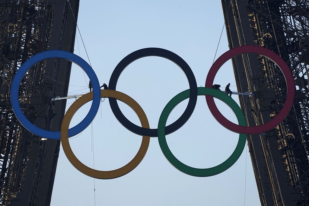 Pekerja menyelesaikan pemasangan cincin Olimpiade di Menara Eiffel, Paris, Perancis, Jumat (7/6/2024). Pemasangan itu menandai 50 hari menjelang dimulainya Olimpiade Paris 2024.