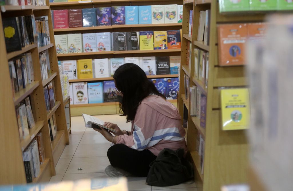 Pengunjung membaca buku diantara lorong sebuah   toko buku di  Jakarta, Kamis (2/2/2023).