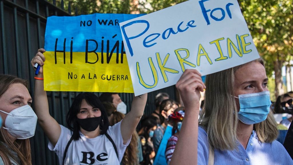 Warga Ukraina memegang poster dalam aksi protes mendukung Ukraina di depan Kedutaan Besar Rusia di Santiago, Chile, Kamis (24/2/2022).