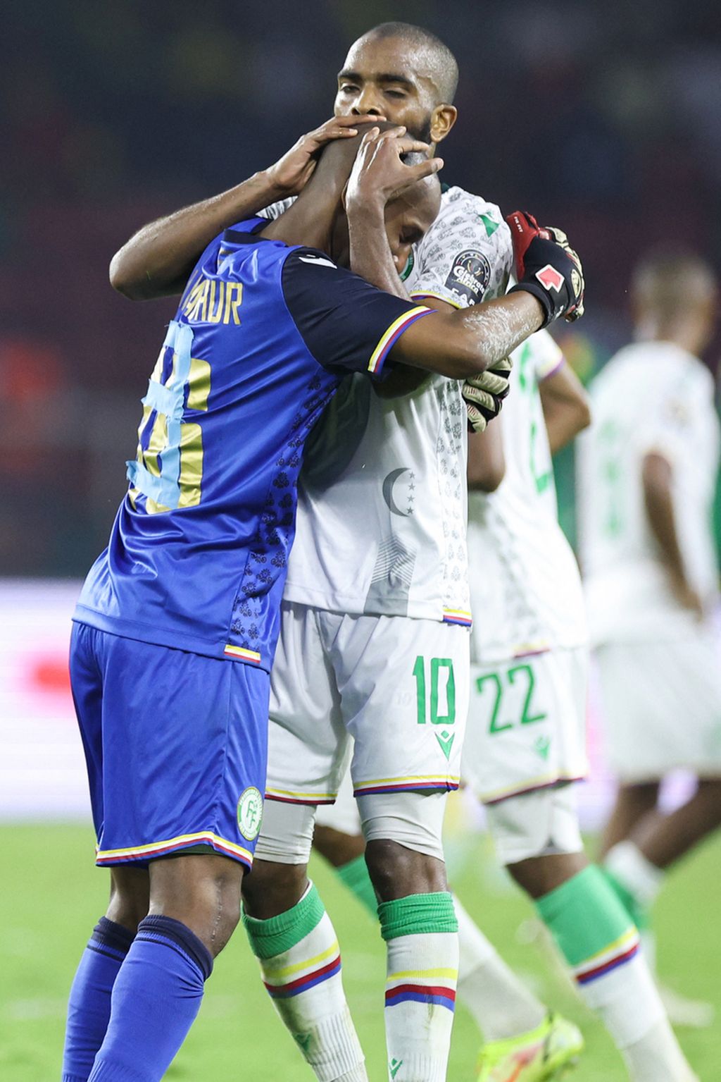 Gelandang Komoro, Youssouf MChangama (kanan), memeluk rekan setimnya, Chaker Alhadhur, seusai laga melawan Kamerun pada babak 16 besar Piala Afrika 2021 , Selasa (25/2/2022) dini hari WIB, di Stadion Stadion Paul Biya, Kamerun. Keduanya tampil brilian meski Komoro tumbang 1-2 dari tim tuan rumah.