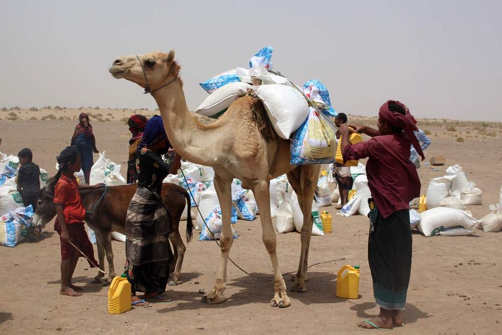 Dalam foto yang diambil pada 29 Maret 2022 tampak sebuah keluarga miskin Yaman menerima bantuan bahan makanan.