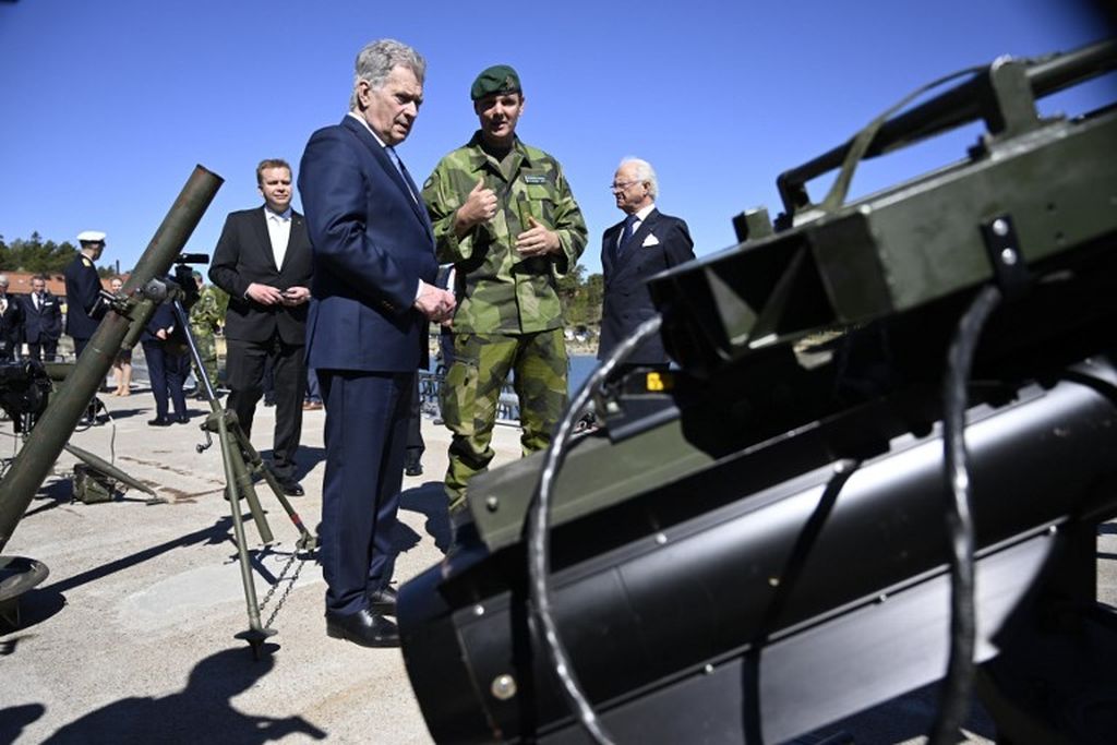 Presiden Finlandai  Sauli Niinisto (ketiga dari kanan), Raja Swedia King Carl XVI Gustaf (kanan), dan Menteri Pertahanan Finlandia Antti Kaikkonen (keempat di kanan) saat mengunjungi resimen Amfibi di luar Stockholm, Swedia, 18 Mei 2022,untuk berbicara dengan para prajurit dan menyaksikan pameran peralatan perang. 