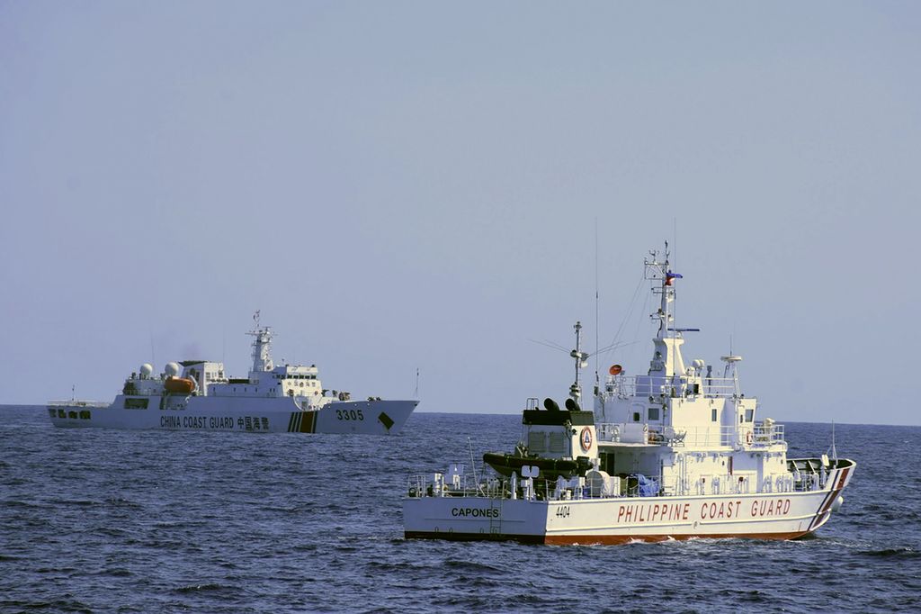 Foto yang dikeluarkan Pemerintah Filipina ini memperlihatkan kapal Penjaga Pantai China (kiri) berlayar di dekat kapal Penjaga Pantai Filipina yang tengah berpatroli di segmen Bajo de Masimioc yang berjarak lebih kurang 200 kilometer  sebelah barat Provinsi Zambales, Filipina, 2 Maret 2022. 