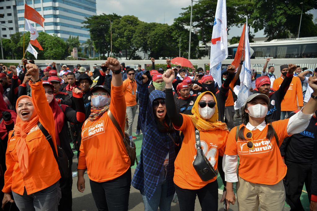 Peserta aksi mengepalkan tangan dengan meneriakkan slogan Partai Buruh saat melakukan unjuk rasa di depan Gedung DPR, Jakarta, Senin (6/2/2023). 