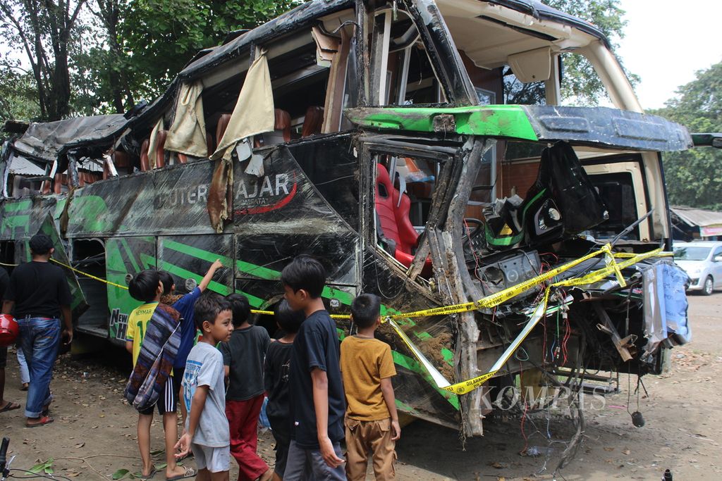 Beberapa anak mengamati bus yang rusak akibat kecelakaan yang diparkir di Terminal Subang, Jawa Barat, Minggu (12/5/2024). Bus bernomor polisi AD 7524 OG yang membawa rombongan SMK Lingga Kencana, Depok, ini terguling di perjalanan pada Sabtu (11/5/2024) petang dan menewaskan 11 orang.
