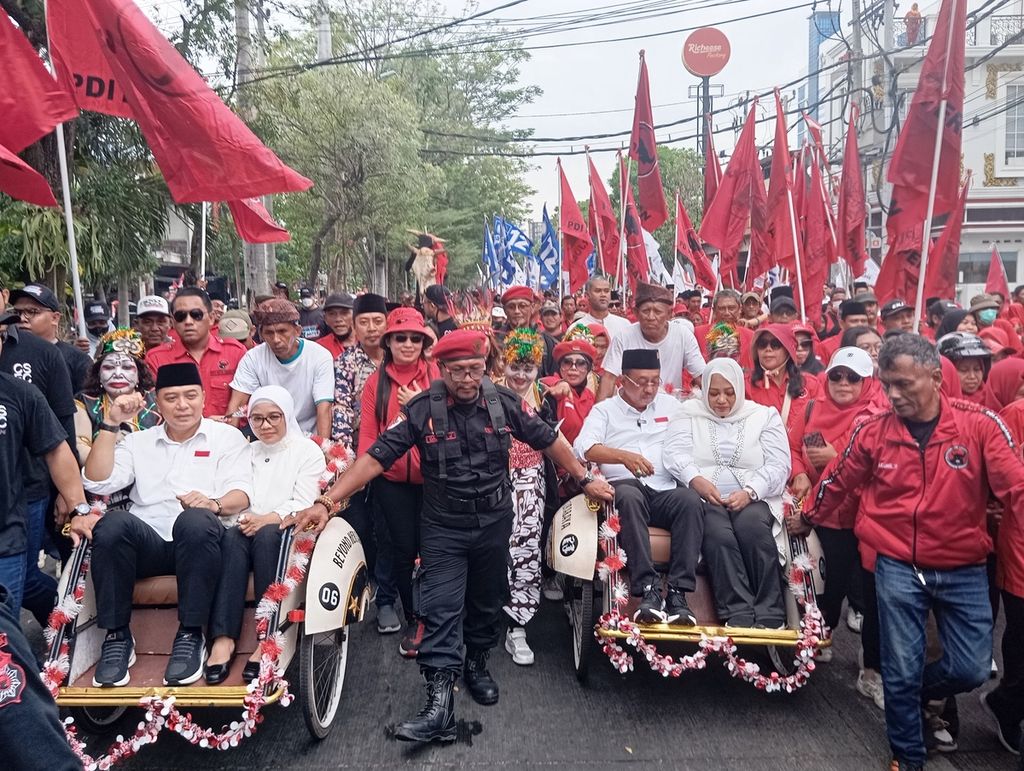 Wali Kota Surabaya Eri Cahyadi (becak kiri) dan Wakil Wali Kota Surabaya Armuji (becak kanan) dalam kirab budaya mendaftar ke Komisi Pemilihan Umum Kota Surabaya, Rabu (28/8/2024). Eri-Armuji diyakini menjadi calon tunggal pemilihan wali kota dan wakil wali kota untuk Surabaya dengan dukungan seluruh partai politik.