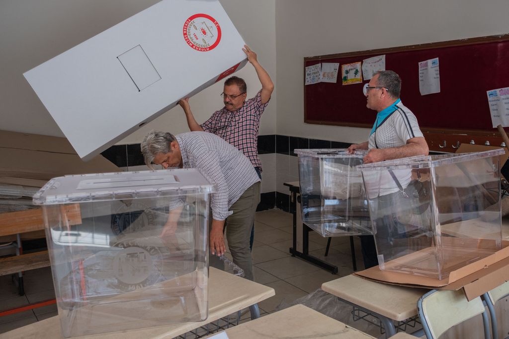 Beberapa petugas pemungutan suara di sebuah sekolah di Antakya, Turki, Sabtu (13/5/2023), tengah mengatur peralatan yang akan digunakan pada pemungutan suara pemilu 2023. 