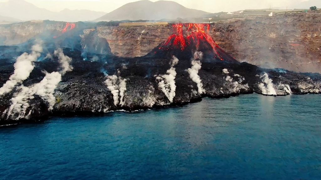 Daratan baru terbentuk di pantai akibat lahar dari Gunung Cumbre Vieja di Pulau La Palma, Kepulauan Canary, Spanyol, Senin (4/10/2021). Saat ini, sungai lava yang mengalir dari gunung hingga pantai lebarnya mencapai 1.250 meter atau 300 meter lebih lebar dari Minggu (3/10/2021) ketika sebagian dinding kawah runtuh. 