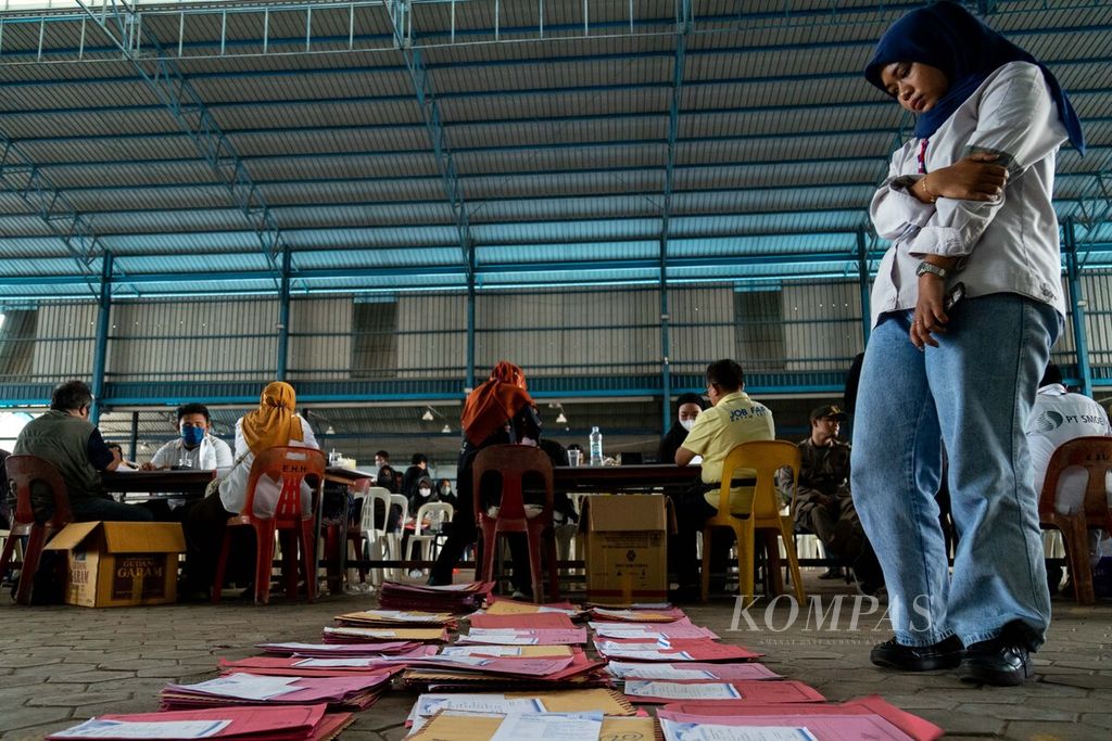 Seorang panitia mengamati tumpukan surat lamaran kerja dari para pencari kerja saat gelaran bursa kerja di Batam, Kepulauan Riau, Rabu (9/11/2022). Ada 32 perusahaan yang terlibat menawarkan 1.880 lowongan dalam acara tersebut.