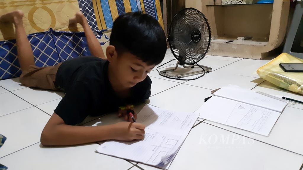 Ahmad Rafa (7), sedang mengerjakan tugas harian sekolah, Kamis (16/4/2020). Setelah selesai mengerjakan Matematika tersebut, Rafa harus memotret dan mengirim tugasnya via aplikasi pesan kepada gurunya. 