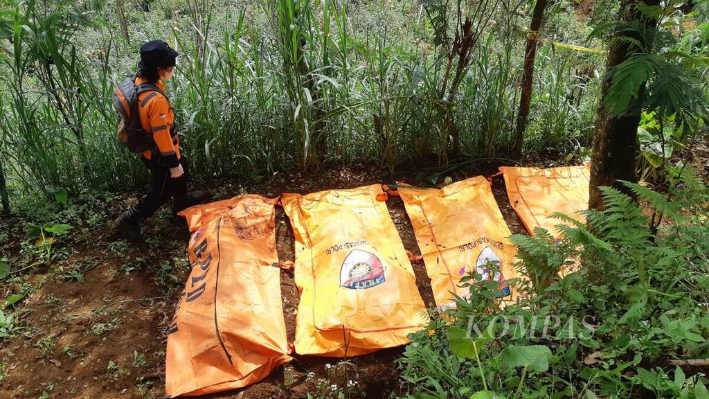 Petugas kepolisian mengecek sejumlah kantong berisi jenazah yang ditemukan terkubur di wilayah Kecamatan Wanayasa, Kabupaten Banjarnegara, Jawa Tengah, Senin (3/4/2023) siang. Sejumlah jenazah itu diduga merupakan korban pembunuhan oleh TH (45) alias Slamet. Slamet merupakan pelaku penipuan dengan modus penggandaan uang.