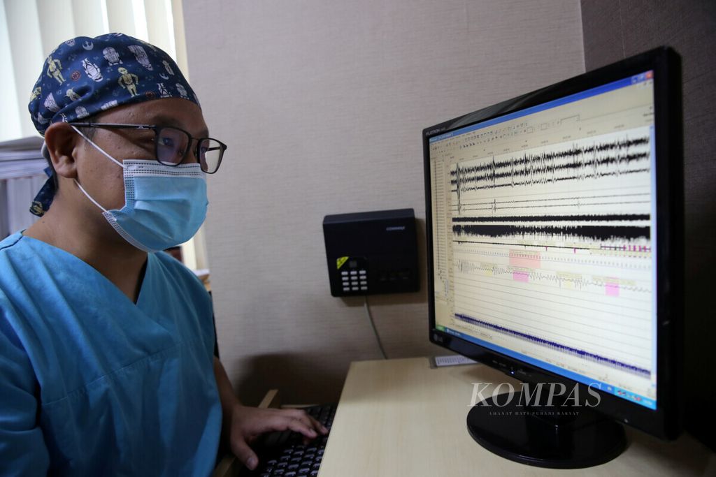 Dokter Andreas Prasadja dari Klinik Gangguan Tidur Rumah Sakit Mitra Keluarga Kemayoran, Jakarta, mengecek layar monitor yang berisi hasil pemantauan pasien dengan gangguan tidur, Rabu (7/4/2021). 