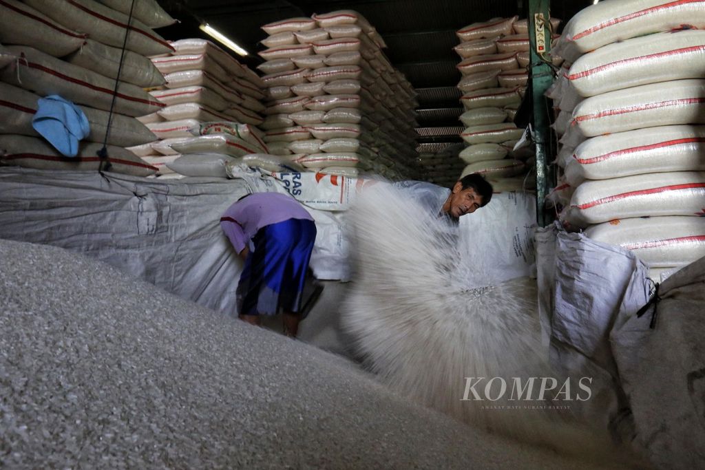 Buruh mengaduk beras di Pasar Induk Beras Cipinang, Jakarta, Selasa (11/7/2023).
