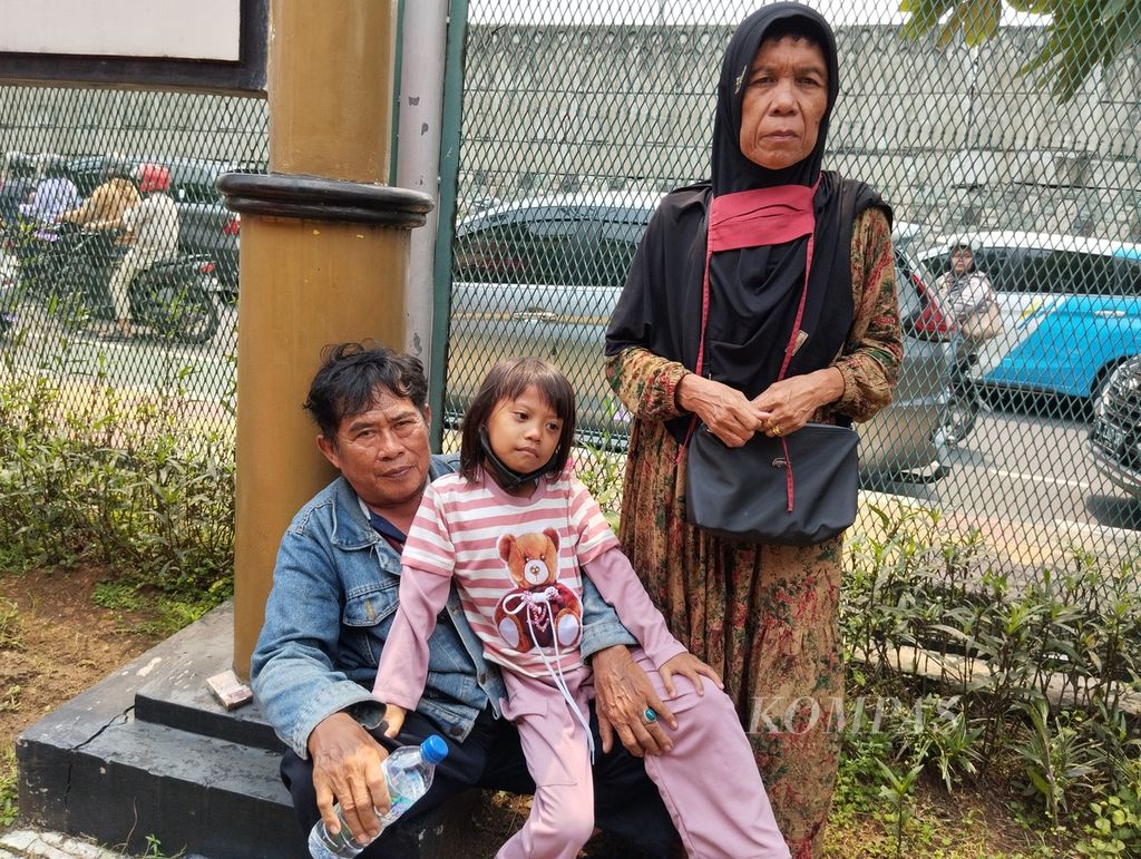 Kholik (58) bersama istri dan cucunya tengah menunggu giliran untuk bertemu salah satu putranya yang sedang menjalani masa binaan di Lapas Kelas I Cipinang, Jakarta Timur, pada Rabu (10/4/2024) siang. 