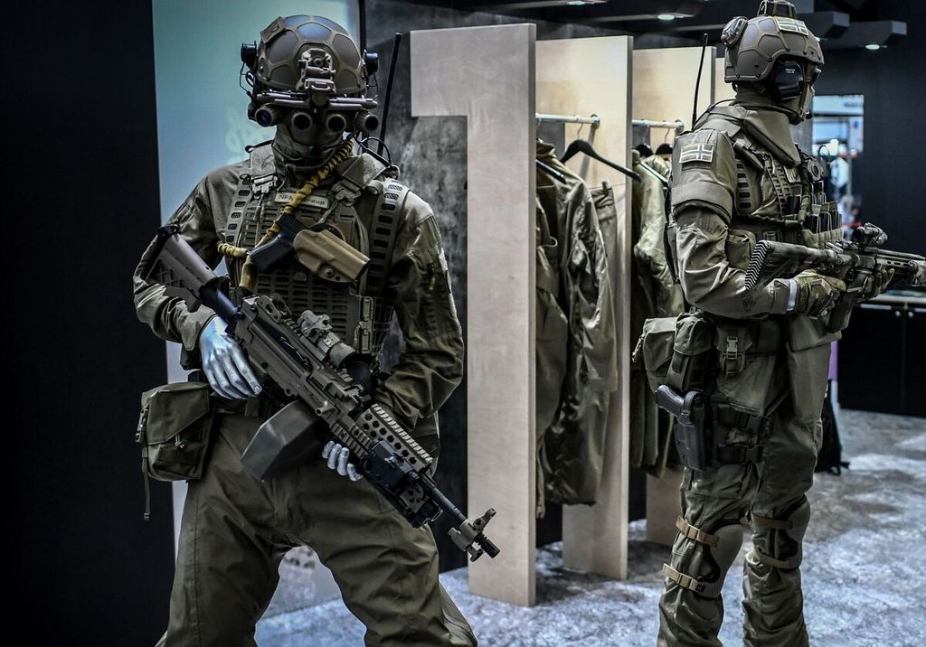 Dalam foto yang diambil pada 21 Oktober 2021 ini tampak dua boneka yang mengenakan beragam perangkat pelindung diri dan perlengkapan militer alam pameran keamanan di Villepinte, utara Paris. 