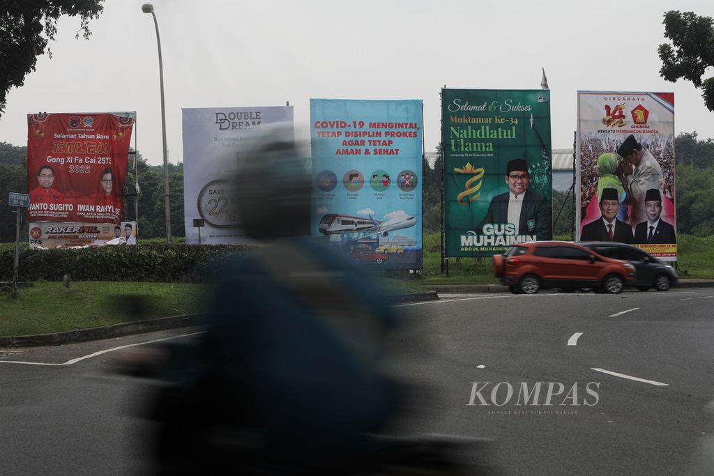Baliho partai politik dan tokoh partai bersanding dengan iklan layanan masyarakat tentang Covid-19 dan iklan komersial di pinggir Jalan Pahlawan Seribu, Tangerang Selatan, Minggu (20/2/2022). 