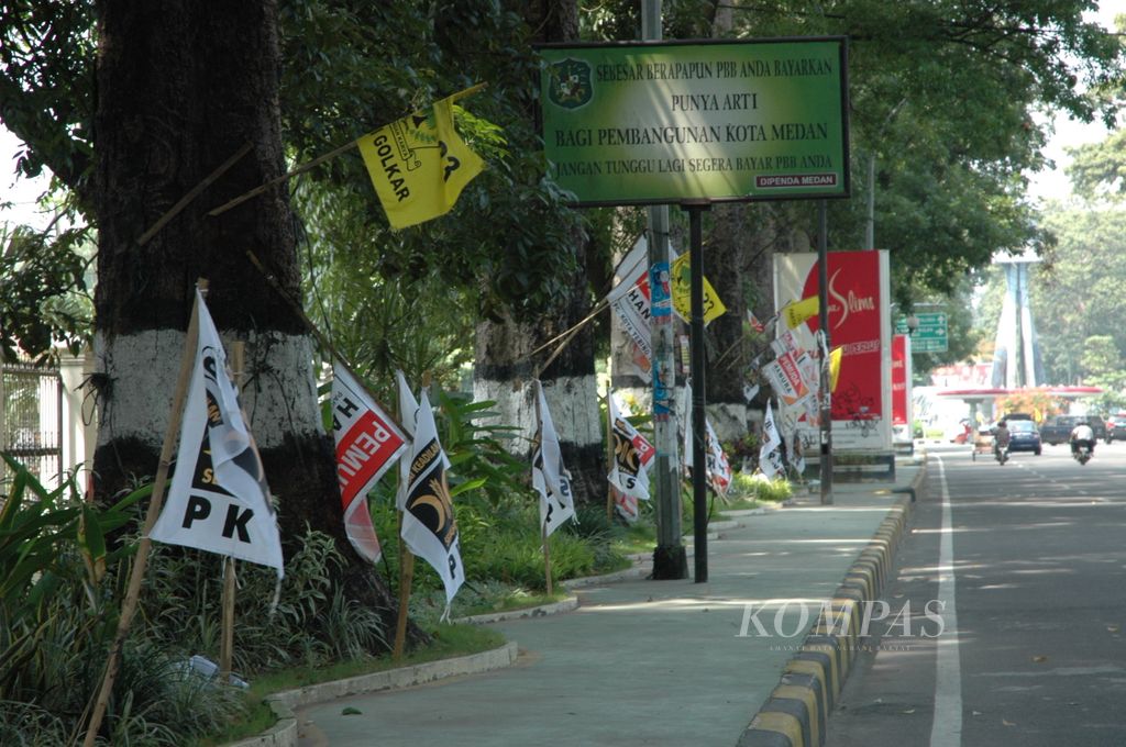 Bendera dan atribut kampanye mulai terlihat terpasang di pepohonan dan taman kota sepanjang jalan protokol di Kota Medan, seperti di Jalan Imam Bonjol, Medan, Senin (8/6/2009). Fasilitas publik seperti pohon peneduh dan taman kota dilarang ditempeli atribut kampanye.