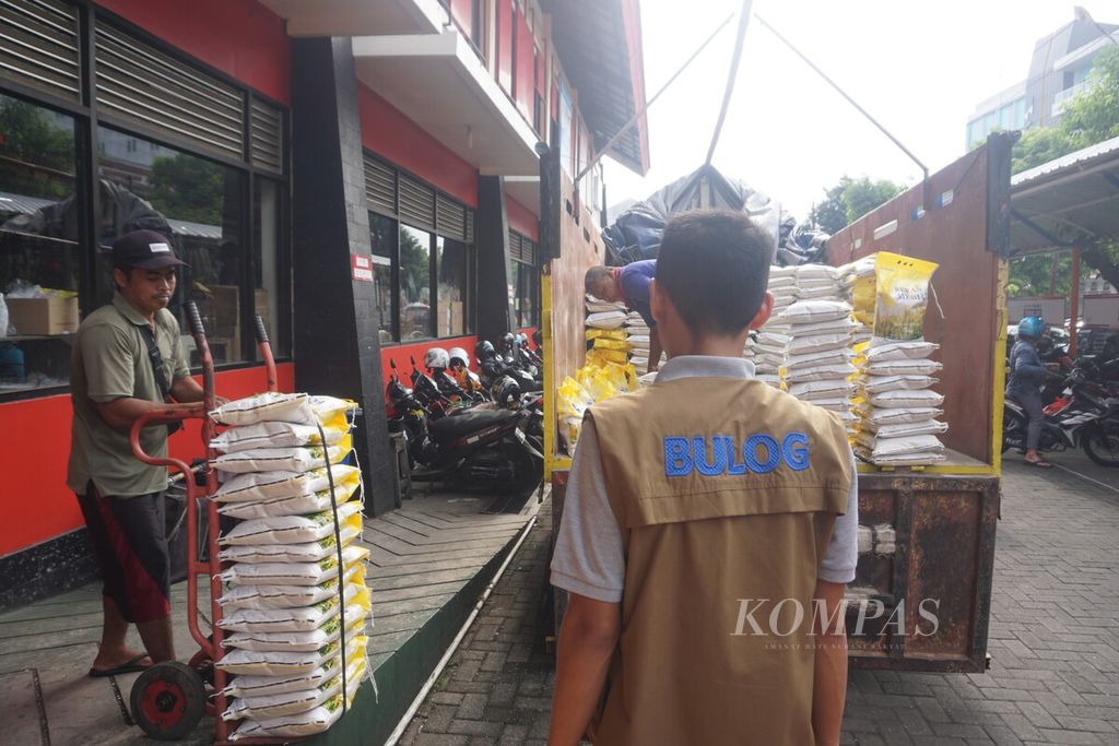 Petugas menurunkan beras Bulog medium dalam rangka operasi pasar di Pasar Manis, Purwokerto, Kabupaten Banyumas, Jawa Tengah, Sabtu (28/1/2023).