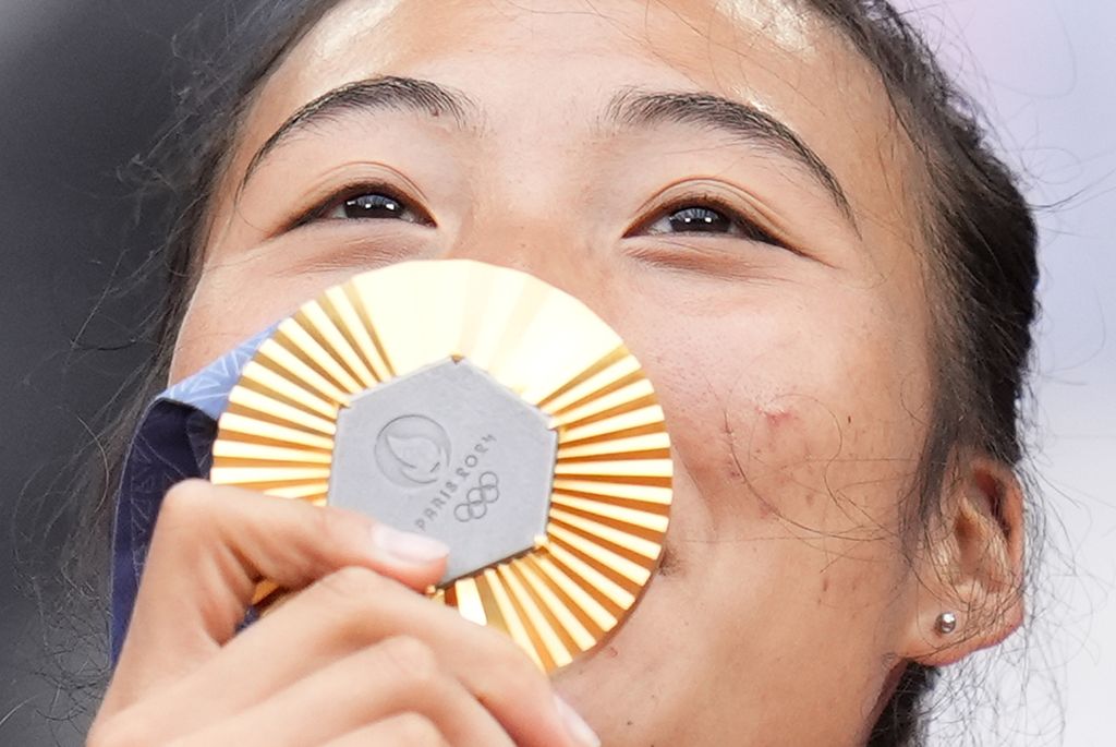 Tunggal putri China, Zheng Qin Wen, mencium medali emas yang diraihnya setelah mengalahkan petenis Kroasia, Donna Vekic, pada final tenis Olimpiade Paris 2024 di Paris, Sabtu (3/8/2024).