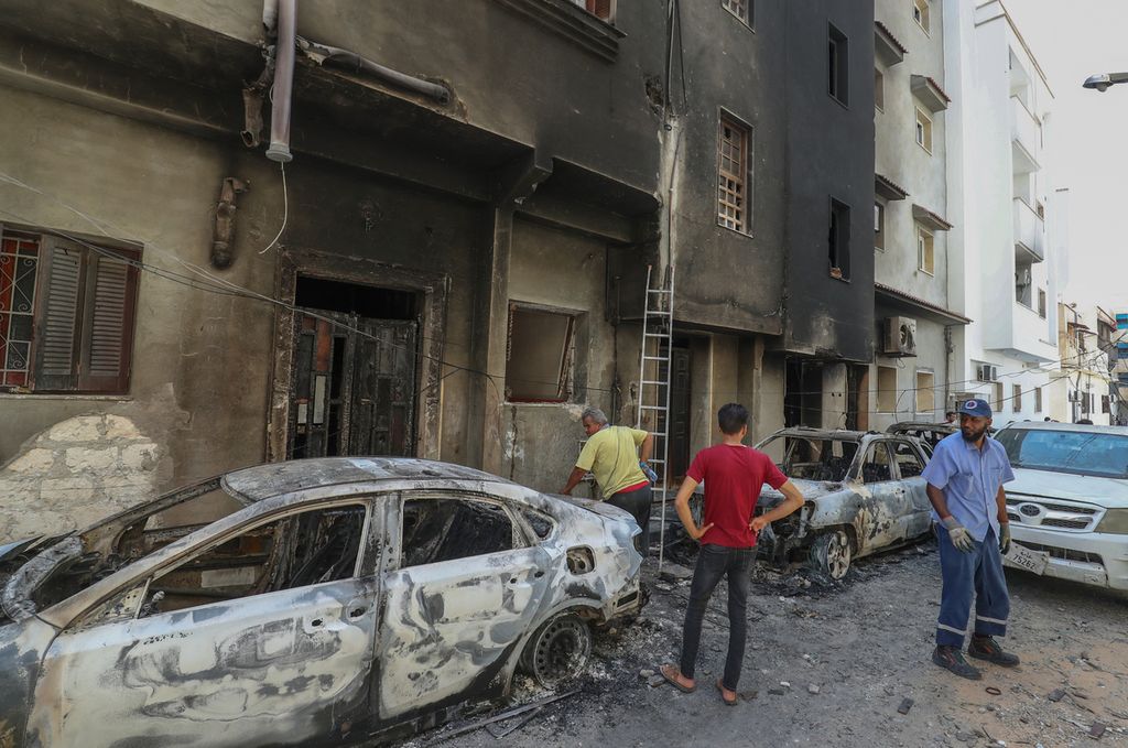 Warga memeriksa kerusakan setelah pertikaian kelompok pendukung Pemerintah Libya dan rivalnya di Tripoli, 28 Agustus 2022. 