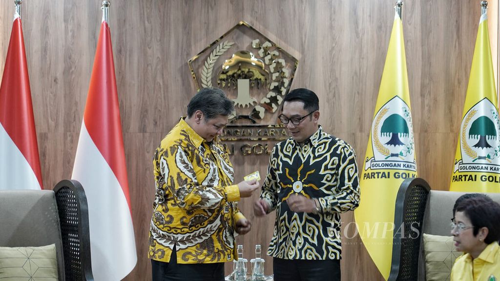 Ketua Umum Partai Golkar Airlangga Hartarto (kiri) menyerahkan kartu keanggotaan partai kepada Gubernur Jawa Barat Ridwan Kamil di sela-sela pertemuan di Kantor DPP Partai Golkar, Slipi, Jakarta, Rabu (18/1/2023). 