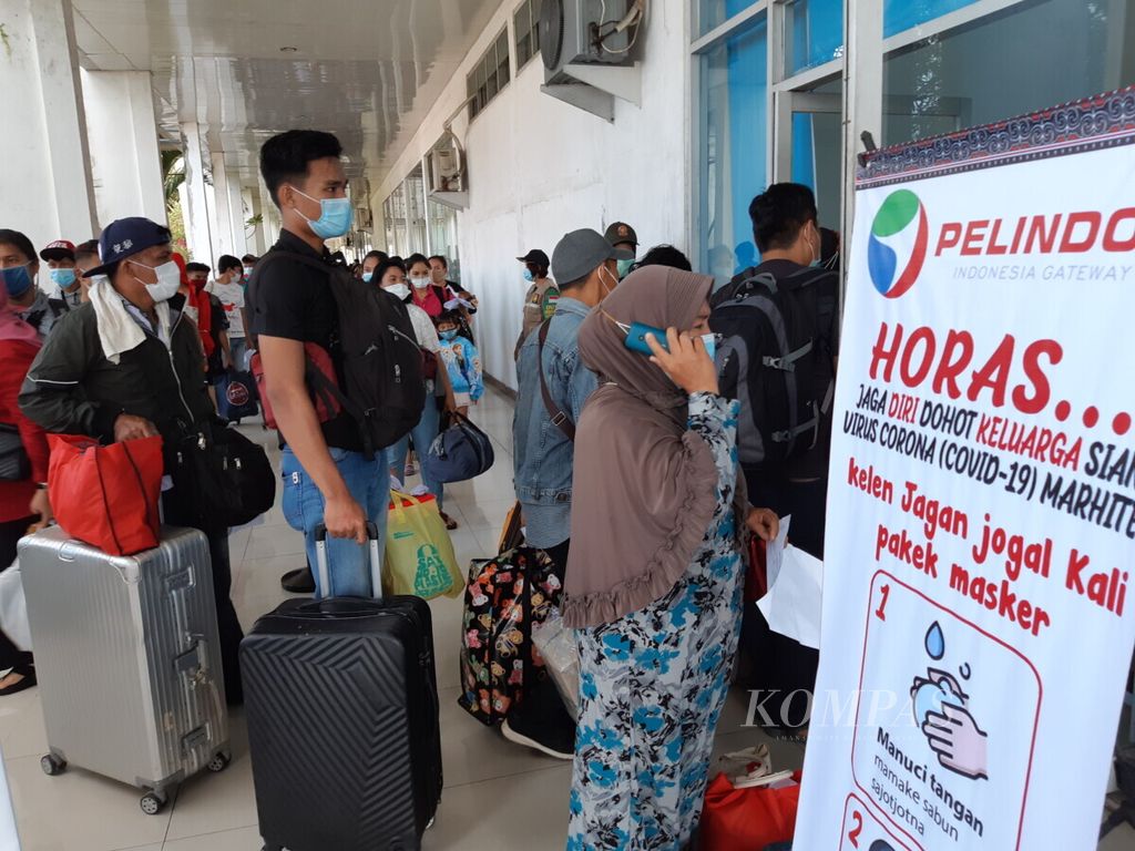 Menjelang Natal dan Tahun Baru, penumpang Kapal Motor Kelud meningkat dari biasa 700 menjadi 1.370 orang tiba di Pelabuhan Belawan, Medan, Sumatera Utara, Senin (21/12/2020). Antrean panjang pun tak terelakkan saat pemeriksaan kartu kewaspadaan kesehatan Covid-19. 