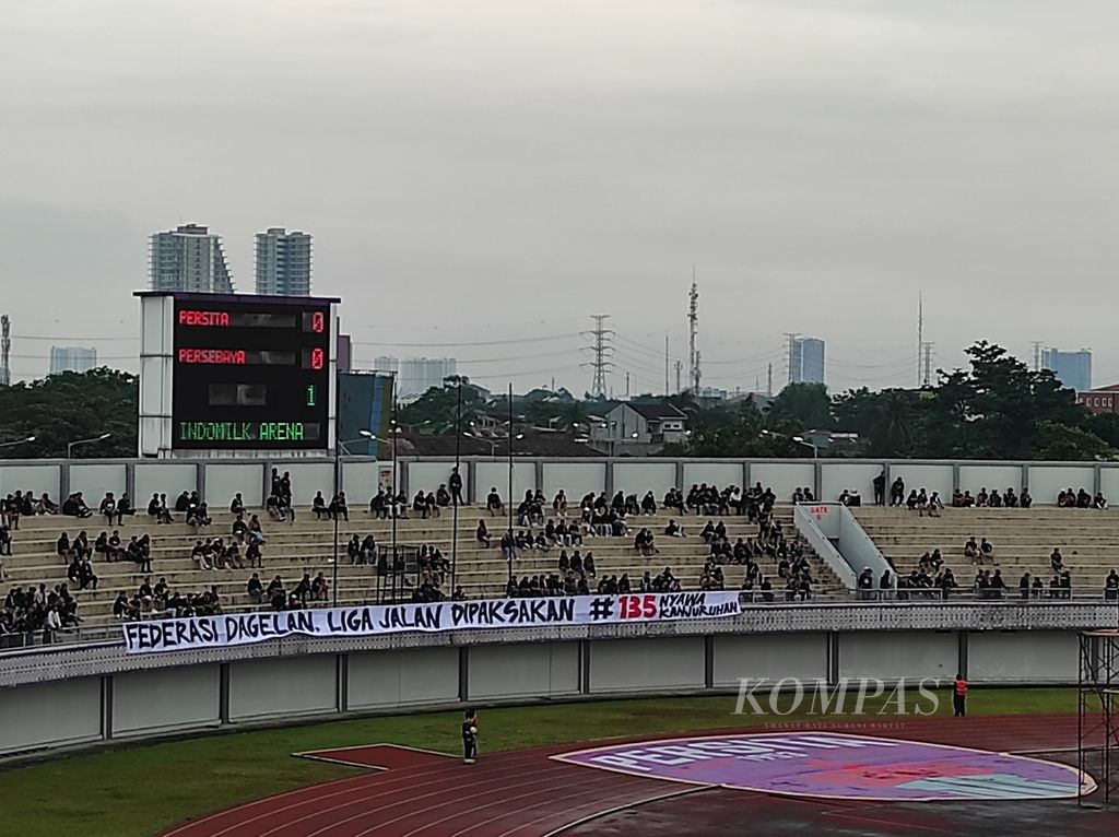 Spanduk yang mengandung pesan protes terhadap jalannya sisa Liga 1 musim ini dibentangkan pendukung Persita Tangerang pada laga menghadapi Persebaya Surabaya, Rabu (18/1/2023), di Arena Indomilk, Tangerang, Banten. Persita menelan kekalahan telak 0-5.