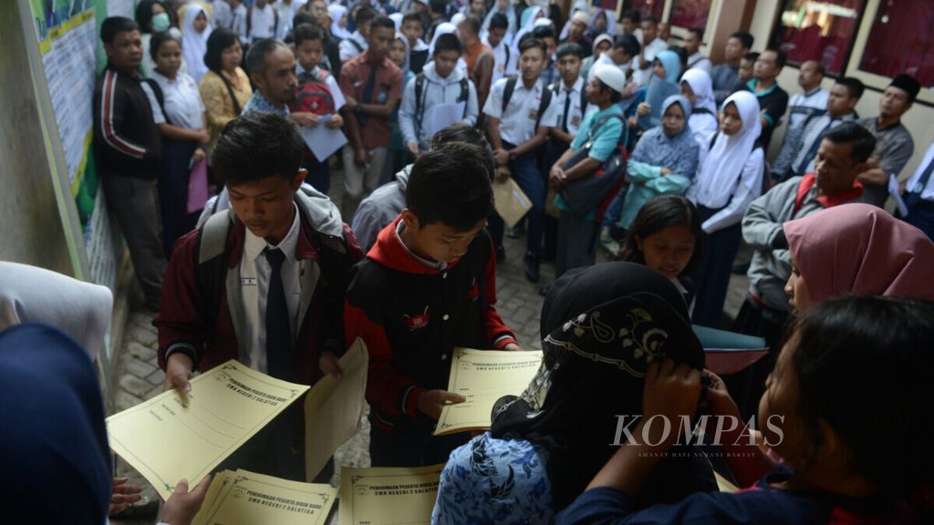 Murid antre mengambil formulir pemeriksaan kesehatan sebagai salah satu syarat pendaftaran siswa baru di SMK Negeri 2 Salatiga, Kota Salatiga, Jawa Tengah, Senin (17/6/2019).