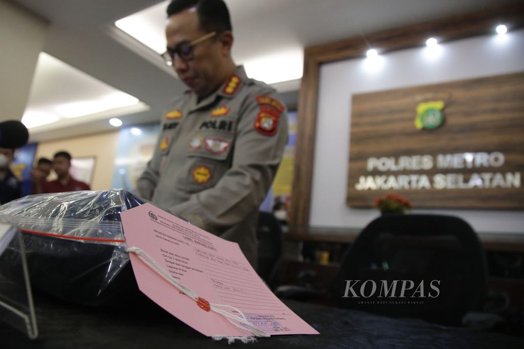 Kapolres Metro Jakarta Selatan Komisaris Besar Ade Ary memeriksa barang bukti pakaian milik tersangka Shane Lukas Rotua Pangondian Lumbantoruan dan telepon genggam milik tersangka Mario Dandy Satrio sebelum memberikan keterangan kepada wartawan di Mapolres Metro Jakarta Selatan, Jumat (24/2/2023). 