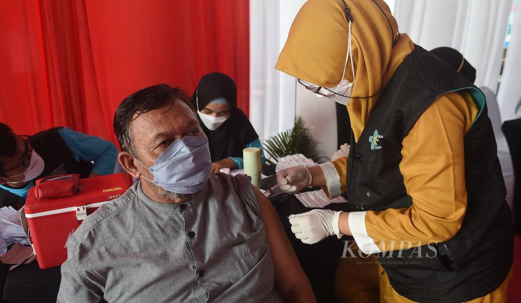 Warga mendapatkan vaksinasi saat Kick Off Vaksinasi Booster Jawa Timur di Kantor Dinas Ketenagakerjaan Jatim, Kota Surabaya, Rabu (12/1/2022). Sebanyak 100 warga menjalani vaksin <i>booster </i>tersebut. Vaksin <i>booster </i>ditujukan bagi masyarakat berusia 18 tahun ke atas dengan prioritas warga lansia. 