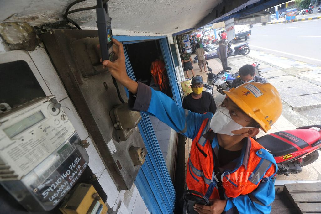 Petugas PLN mengukur beban pada jaringan listrik milik pelanggan di kawasan Taman Sari, Jakart Barat, Selasa (9/2/2021).  