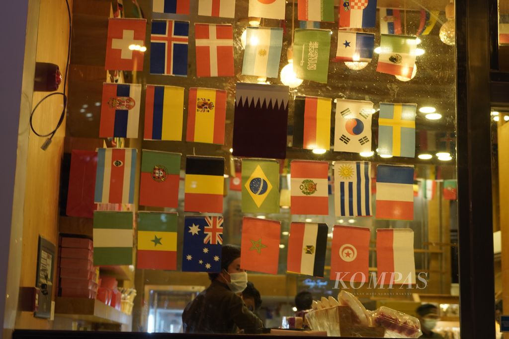 Toko-toko di Doha, Qatar, memajang bendera-bendara peserta Piala Dunia 2022 sebagai hiasan (16/11/2022). Penjualan <i>merchandise </i>seperti bendera atau kostum peserta World Cup menjadi salah satu lini perputaran ekonomi Piala Dunia. 